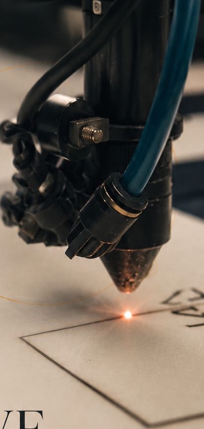 Close-up of the laser cutter head mid-cut