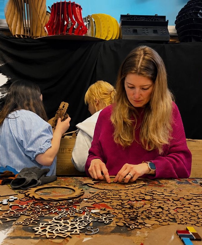 Makers working together at a table covered in laser-cut pattern pieces